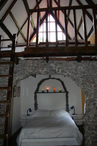 Un dormitorio con una cama en una pared de piedra. en Top Of The Mountain - The Eagles Nest, en Las Nubes