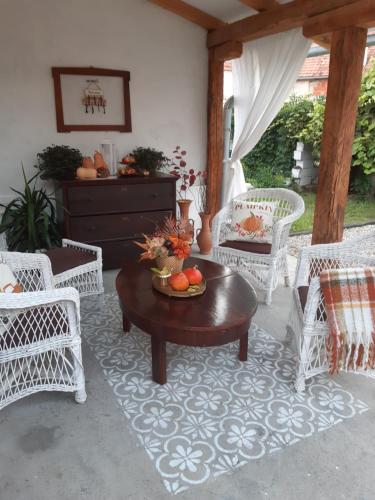 a porch with white wicker chairs and a coffee table at Bela Vila in Negotin