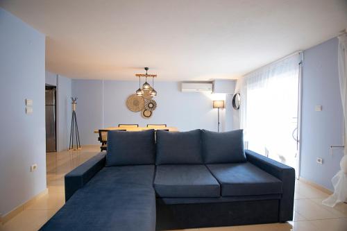 a living room with a blue couch and a table at Maisonette PT in Perea