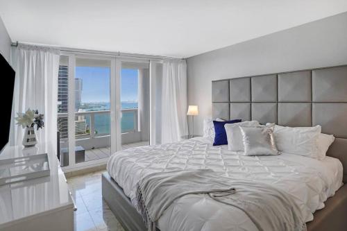 ein Schlafzimmer mit einem großen Bett und einem großen Fenster in der Unterkunft Wildest Dreams Penthouse! Dreams Do Come True in Miami