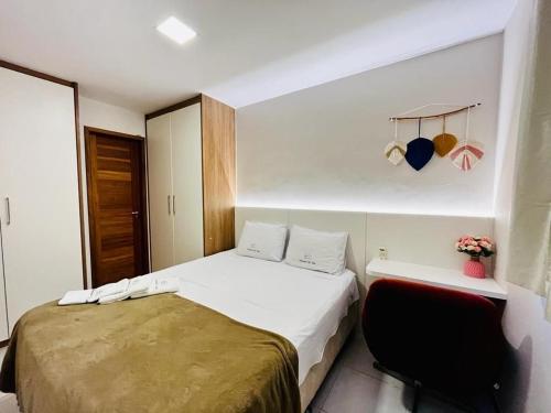 a small bedroom with a bed and a chair at Praia Dourada in Vila Velha