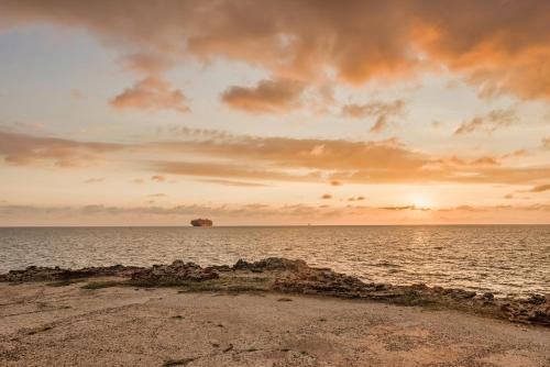 an island in the middle of the ocean at sunset at Castillete Hotel & Beach Club in Tierra Bomba