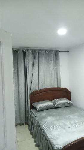 Bett in einem Zimmer mit einem Fenster mit Vorhängen in der Unterkunft Idiliz in Borj
