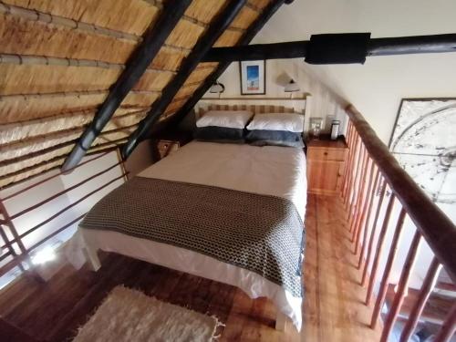 sypialnia z dużym łóżkiem na poddaszu w obiekcie Collie Cottage w mieście Clarens