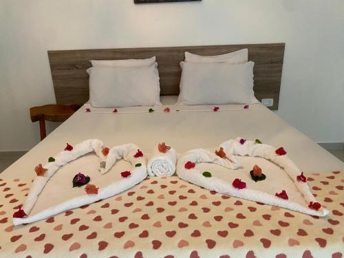 a bed with two towels with hearts on it at Pousada Águas de Tamandaré in Tamandaré