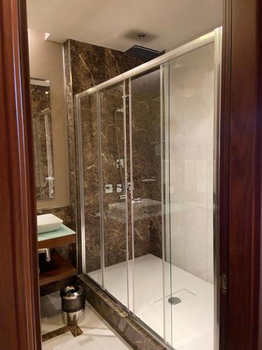 a shower with a glass door in a bathroom at Borjomi Likani Health & Spa Centre in Borjomi