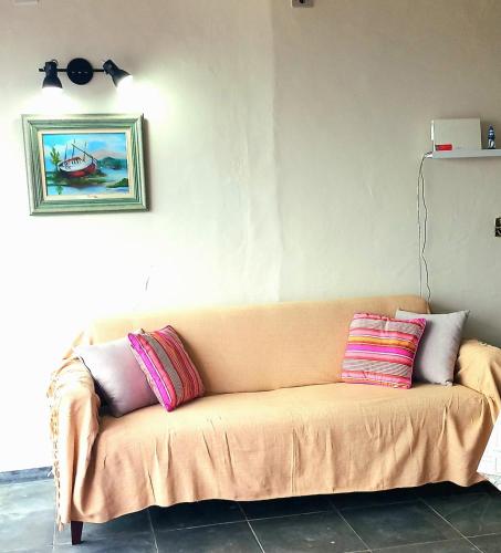 a couch with three pillows on it in a room at Apartamento Ubatuba Vista para o Mar in Ubatuba