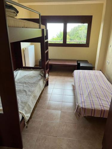 a room with two bunk beds and a window at ZEUS Viewpoint Villa: Three floors of beauty in Neos Panteleimonas