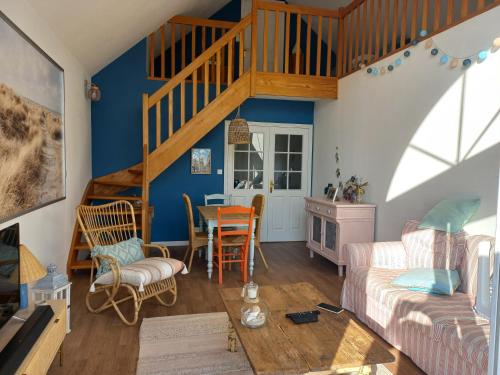 un salon avec des murs bleus et un escalier en bois dans l'établissement Superbe duplex proche de la mer, à Saint-Martin-Boulogne