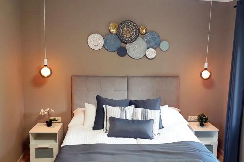 1 dormitorio con 1 cama con placas en la pared en The Luxo Wine Museum Hotel, en Kaba