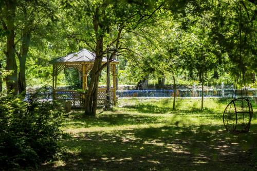 a gazebo in the middle of a park with trees at Borjomi Likani Health & Spa Centre in Borjomi