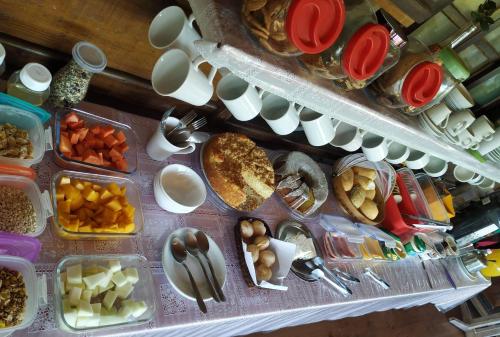 a table filled with plates and bowls of food at Joaquina 433 - Pousada Floripa in Florianópolis