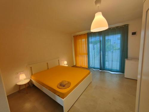a bedroom with a yellow bed and a large window at SunBA in 2 Mai