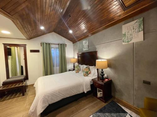 a bedroom with a white bed and a wooden ceiling at Camino Verde B&B Monteverde Costa Rica in Monteverde Costa Rica