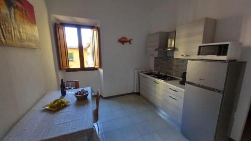 a kitchen with a refrigerator and a table and a window at L'Iris in Livorno