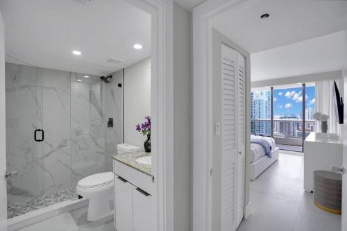 a white bathroom with a toilet and a shower at Superstar! Penthouse with Water and Park Views! in Miami