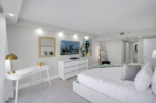 a white bedroom with a white desk and a bed at Superstar! Penthouse with Water and Park Views! in Miami