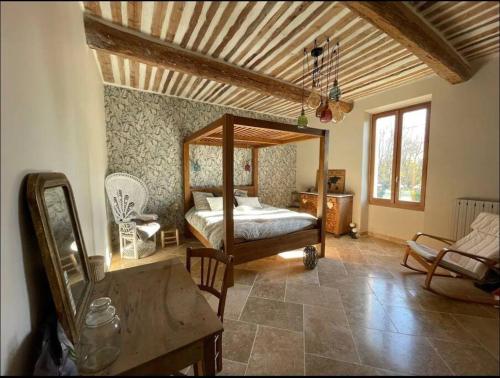 une chambre avec un lit à baldaquin dans une pièce dans l'établissement Mas l Oustau de Memei, à Althen-des-Paluds