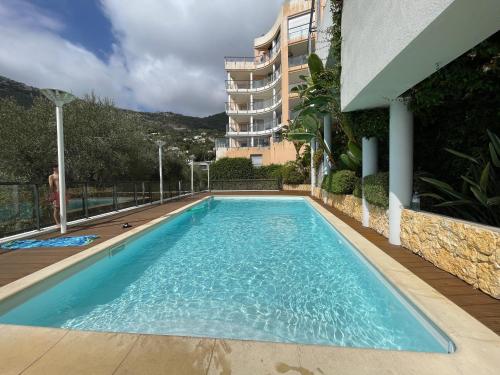 une piscine devant un immeuble dans l'établissement Deux pièces, parking et piscine, à Beausoleil