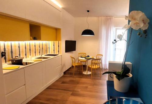 une cuisine avec des placards blancs et une table. dans l'établissement CASA Eduardo e Titina, à Sorrente