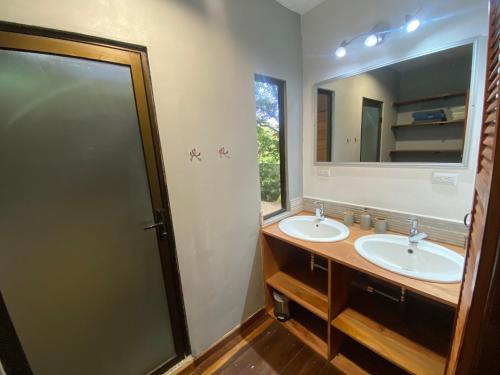 a bathroom with two sinks and a mirror at CASA NATURaL in Brasilito