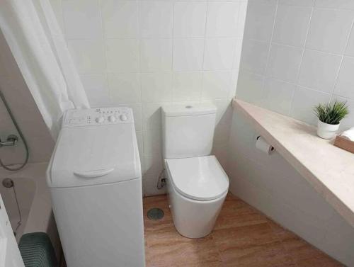 a white bathroom with a toilet and a sink at Apartamento golf del sur in Santa Cruz de Tenerife