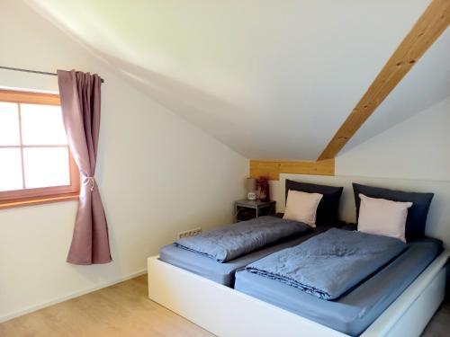 a bed in a room with a window at Ferienwohnung Menter in Marquartstein