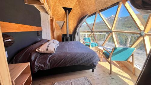 a bedroom with a bed and a large window at Terrazas de Meliquina in Lago Meliquina