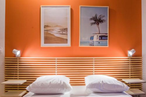 ブリーヴ・ラ・ガイヤルドにあるAppartement Cosy - Lumineux - LESTANG - 2 personnesの壁に写真2枚が飾られた客室内のベッド2台