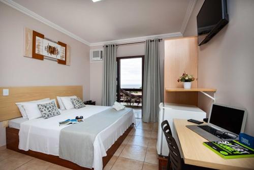 維拉維爾哈的住宿－提莫內羅旅館，一间卧室配有一张床和一张带电脑的书桌