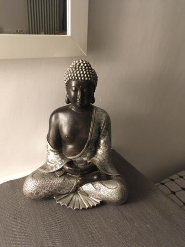 a statue of a buddha sitting on the floor at Blackboard House in Bari