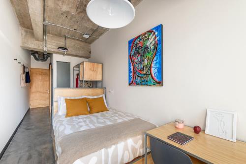 a small bedroom with a bed and a desk at Triver Coliving in Mexico City