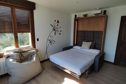 um quarto com uma cama e uma grande janela em Estudio moderno en La Alpujarra granadina em Busquístar