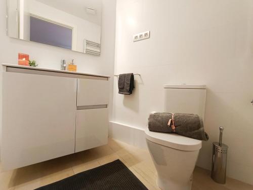 ein Bad mit WC und ein TV an der Wand in der Unterkunft By Plaza Universidad Rooms in Barcelona