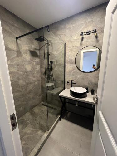 a bathroom with a shower with a sink and a mirror at Feeling Home 2 in Oradea