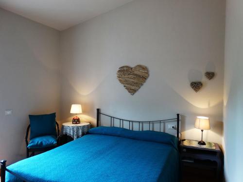 a bedroom with a blue bed and hearts on the wall at Villa Gemma in Porto Azzurro