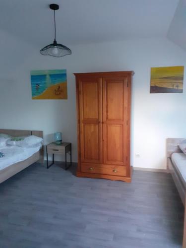 1 dormitorio con puerta de madera, cama y mesa en Le Gambetta, en Flixecourt