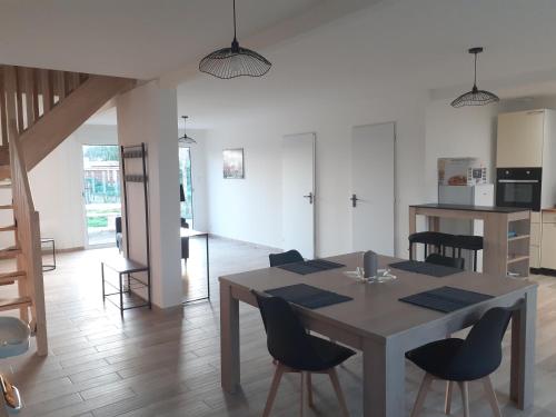 a kitchen and dining room with a table and chairs at Le Gambetta in Flixecourt