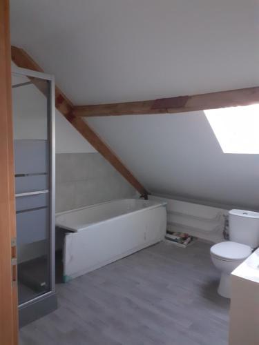 a bathroom with a bath tub and a toilet at Le Gambetta in Flixecourt