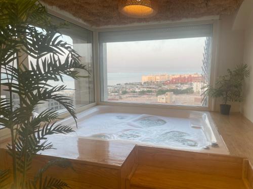 a large bath tub in a room with a large window at Suite 69 in Hurghada