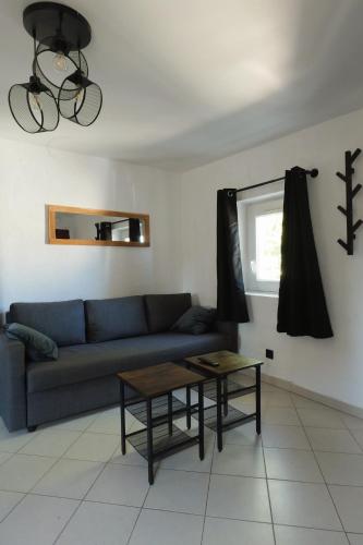 sala de estar con sofá azul y mesa en Appartement centre-ville Pierrelatte - proche toute commodité, en Pierrelatte