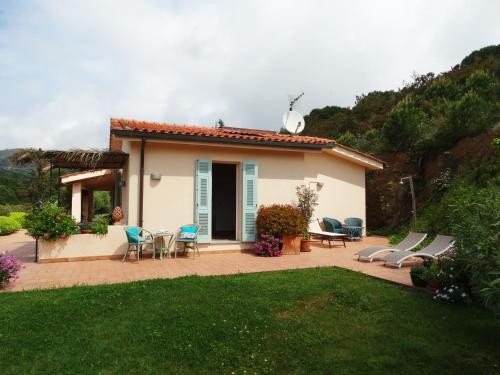 een klein huis met een patio en een tuin bij Villa Gemma in Porto Azzurro