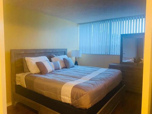 a bedroom with a large bed with pillows and a television at Amazing Guest House in West Palm Beach