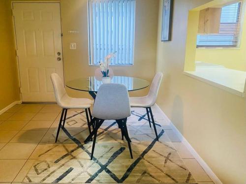 a dining room with a glass table and white chairs at Amazing Guest House in West Palm Beach