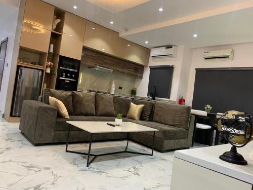 a living room with a couch and a table at Excellent 2 bed apartment in Lekki Phase1 With SuperFast Wi-fi & 247 Power in Lekki