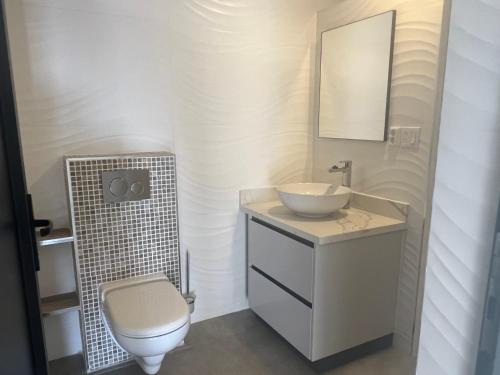 a white bathroom with a sink and a toilet at Lagun Sunset Resort All Natural Clothing Optional in Lagun