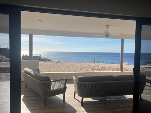 a living room with a view of the ocean at Lagun Sunset Resort All Natural Clothing Optional in Lagun