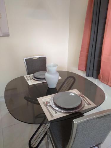 a glass table with plates and a vase on it at Tropical Hideaway in Nassau
