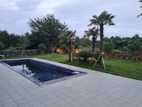 a swimming pool in the middle of a yard at Almare Woljeong in Jeju