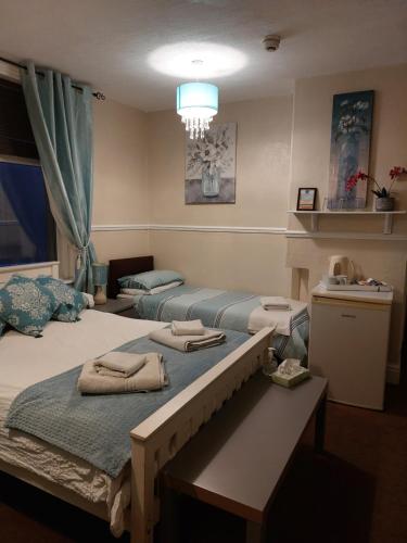 ein Zimmer mit 2 Betten und Handtüchern darauf in der Unterkunft Lynbar guesthouse in Blackpool